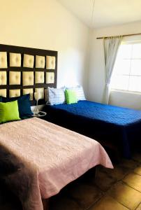 新巴利亚塔Casa Angeles的一间卧室设有两张床和窗户。