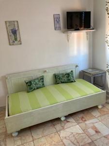Lunifinestra tra cielo e mare的配有电视的客房内的一张绿色床