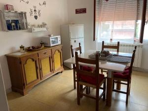 Lunifinestra tra cielo e mare的厨房配有桌子、桌子和冰箱。