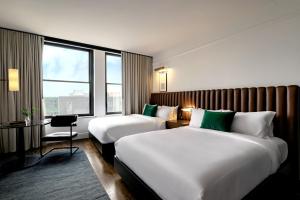 德梅因Surety Hotel的酒店客房设有两张床、一张书桌和一个窗户。