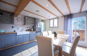 莫尔济讷Beautiful 3 Bedroom Chalet in Morzine的厨房配有蓝色橱柜和桌椅