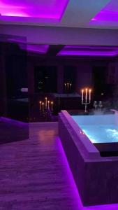 黑尔姆施泰特Loft mit Whirlpool Sauna Kino nähe Wolfsburg的一间带紫色灯浴缸的客房