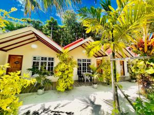 图杜Manta Stay Thoddoo, Maldives的前面有棕榈树的房子
