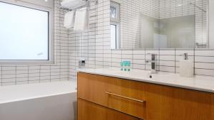 Port Adelaide塞玛佛尔水滨公寓的一间带水槽、浴缸和镜子的浴室