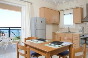 菲尼孔塔西娅一室公寓酒店的厨房配有桌椅和冰箱。