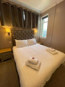 洛哈尔什教区凯尔高地The Skye Bridge Hotel的一间卧室配有一张大床和毛巾