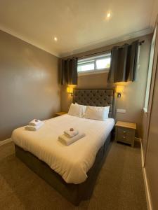 洛哈尔什教区凯尔高地The Skye Bridge Hotel的一间卧室配有一张床,上面有两条毛巾