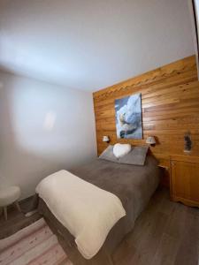 圣费朗索瓦-隆尚Appartement lumineux aux pieds des pistes的一间卧室设有一张床和木墙