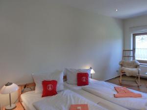 HirschburgFerienwohnung NH5的一间卧室配有两张带红色枕头的床
