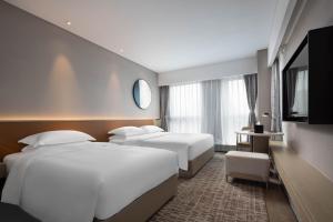 杭州杭州礼顿酒店（ 所有房型入住均赠送软饮）的一间酒店客房,设有三张床和一台平面电视