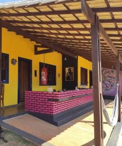 圣湖镇Das Marias Hostel的一座带木凉棚和红砖的建筑