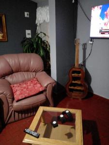 马拉圭Confort y tranquilidad al 100%的客厅配有真皮沙发和吉他