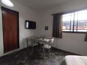 莫龙Alojamiento Entero con Excelente Ubicación的客房设有桌椅和窗户。