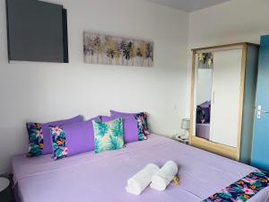 波拉波拉Lokai house的一间卧室配有一张紫色床和两条毛巾