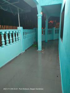 波德申Teratak Port Dickson Homestay Mus Only的建筑的走廊,有蓝色的墙壁和柱子