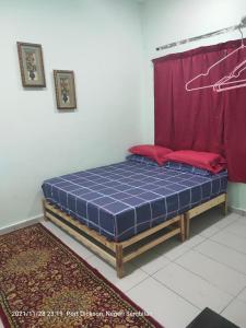波德申Teratak Port Dickson Homestay Mus Only的红色窗帘的房间的一张床位