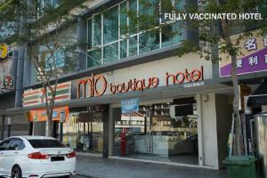 马六甲MIO BOUTIQUE Hotel的停在大楼前的白色汽车