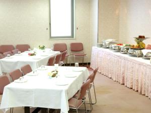 京都京都帕尔赛斯旅馆的一间有白色桌布的房间的一排桌子