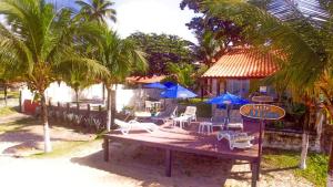 嘎林海斯港Pousada Santo Aleixo的海滩上的桌椅和遮阳伞