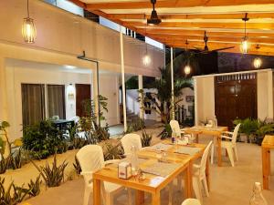 图杜Dhonkamana Stay的配有木桌和白色椅子的餐厅