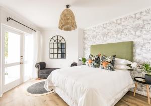 普利登堡湾Plett Holiday Stay with Pizza Oven and Views的卧室设有一张白色大床和一扇窗户。