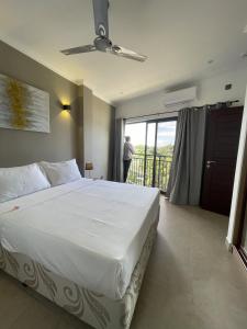 博瓦隆B Holiday Apartments的一间带一张白色大床的卧室和一个阳台