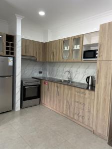 博瓦隆B Holiday Apartments的厨房配有木制橱柜和不锈钢用具