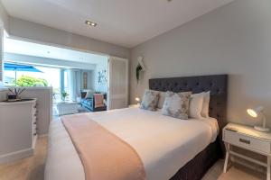 欧尼罗亚Oneroa Bay Villas的一间卧室设有一张大床和大窗户