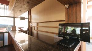 安吉利斯RedDoorz @ Marifa Hotel Angeles Pampanga的一间厨房,厨房内配有一个柜台,上面配有电视