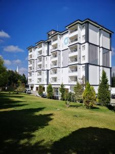 Gazligol巴萨兰拉尔温泉公寓式酒店的一座带草地的大型白色公寓楼