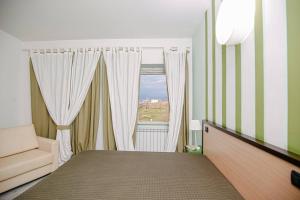 庞特卡格纳诺Hotel Quadrifoglio的一间小卧室,配有床和窗户