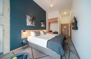 基辅Amarant Urban Hotel by CHM的一间卧室设有一张床和蓝色的墙壁