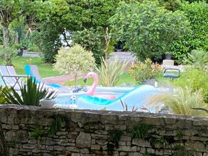 Saint-Sauveur-dʼAunisLa Rochelle et l'Aunis的院子里的游泳池,有粉红色的火烈鸟