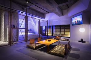 东京艺术家酒店 - 秋叶原BnA一室公寓的客厅配有桌子和床。
