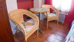 阿雷纳斯德圣佩德罗勘查尔宾馆的两个柳条椅和一张桌子