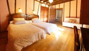 阿雷纳斯德圣佩德罗勘查尔宾馆的一间卧室设有两张床,铺有木地板