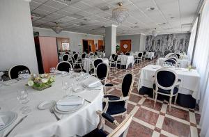 比亚雷亚尔Hotel Vila-real Azul的宴会厅配有白色桌椅和白色的桌布