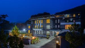 ErshilipuFloral Hotel Jixian Heping Heyuan Jizhou Karst Cave Ares Valley的一座大建筑,晚上灯亮