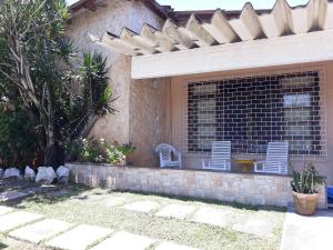 里约达欧特拉斯Ótima casa de praia com piscina的砖墙上带两把椅子的庭院