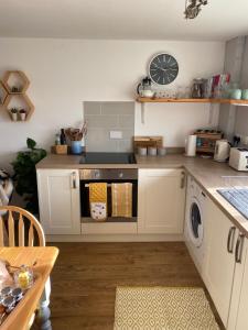 奇平诺顿Cosy Cotswolds Self-Contained One Bedroom Cottage的厨房配有炉灶和洗衣机。