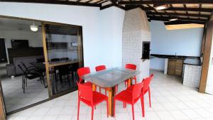 邦比尼亚斯1021 - Cobertura em Bombinhas com Vista para o Mar的一间用餐室,配有红色的椅子和桌子