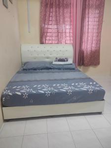 日得拉Homestay Tengku Maheran的卧室内的一张床位,配有粉红色窗帘