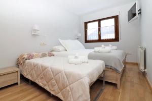 维耶拉Apartamento Besiberri Vielha的配有2张床的白色墙壁和窗户。