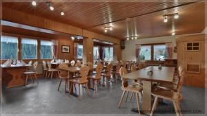 圣安特尼恩Gasthaus Bellawiese的餐厅设有木桌、椅子和窗户。