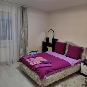 科布林Гостиница Суворов的一间卧室配有一张大紫色床和紫色枕头