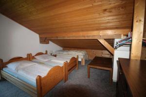 瑟尔Haus Gerdi的木制客房内的一间卧室配有两张床