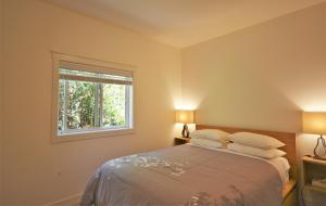 花园湾镇彭德港滨海度假酒店的一间卧室配有带两个枕头的床和窗户