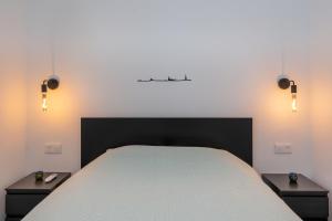 马斯帕洛马斯Tropical Lodge的一间卧室配有一张带2个床头柜的大床
