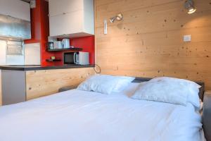 于埃Cosy studio with balcony at the heart of L'Alpe d'Huez - Welkeys的客房内的一张带两个枕头的白色床