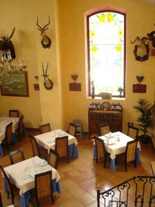 Granja de TorrehermosaHotel Hacienda Don Manuel的餐厅设有白色的桌椅和窗户。